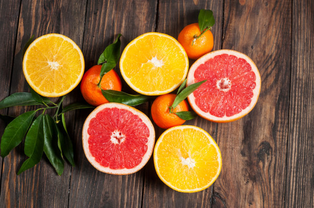 Oranges, tangerines, and grapefruit on a wooden surface