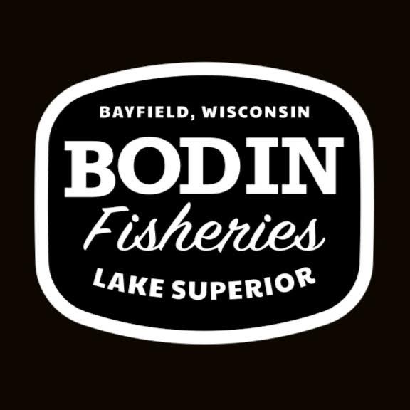 A black and white logo with text that reads "Bayfield, Wisconsin Bodin Fisheries Lake Superior." The design features white letters on a black background with a white border outlining the shape of the logo, reminiscent of the minimalistic style found in coffee shops in Duluth.