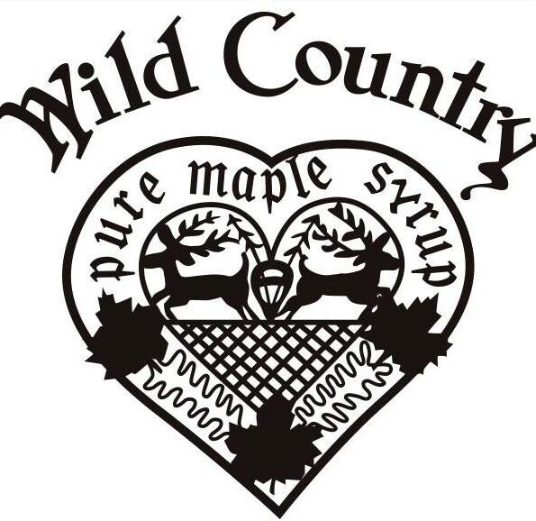 A black and white logo with the text "Wild Country" at the top. Below it, a heart shape contains two deer, maple leaves, and a textured pattern. The text "pure maple syrup" is written along the curve of the heart's interior, evoking a cozy atmosphere reminiscent of enjoying coffee in Duluth.