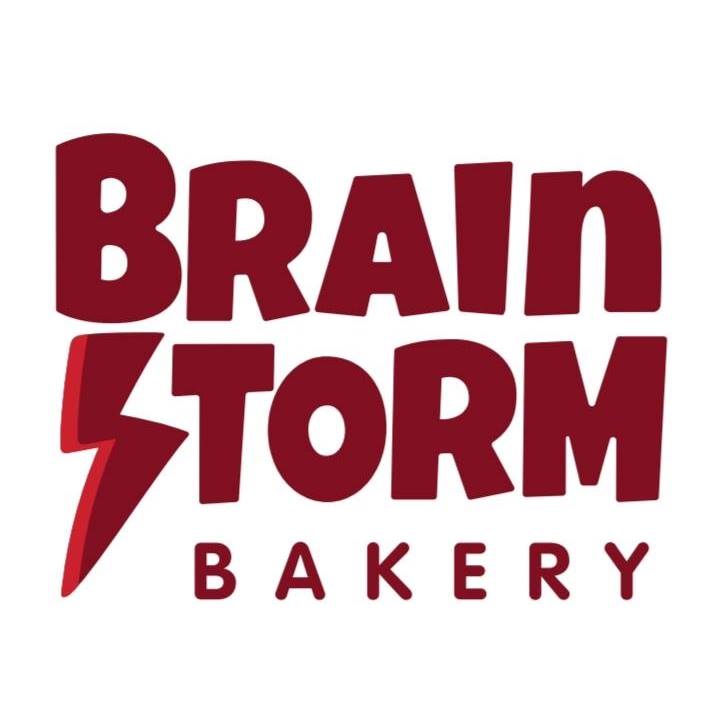 The image showcases the logo for Brainstorm Bakery. It features the name "Brainstorm Bakery" in bold, maroon letters, with a lightning bolt creatively integrated into the letter "S" in "Storm." The white background complements the design, making it perfect for your next coffee stop in Duluth.