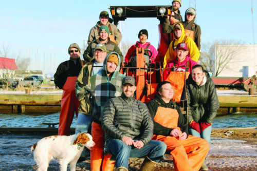 Family and dog on a boat at dock.