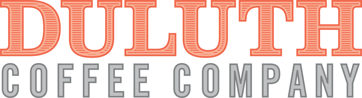 DULUTH COFFEE COMPANY" is displayed in stylized text. The word "DULUTH" is written in bold, uppercase letters with a red and white striped pattern, while "COFFEE COMPANY" is in smaller, gray uppercase letters beneath it, capturing the essence of Coffee in Duluth.