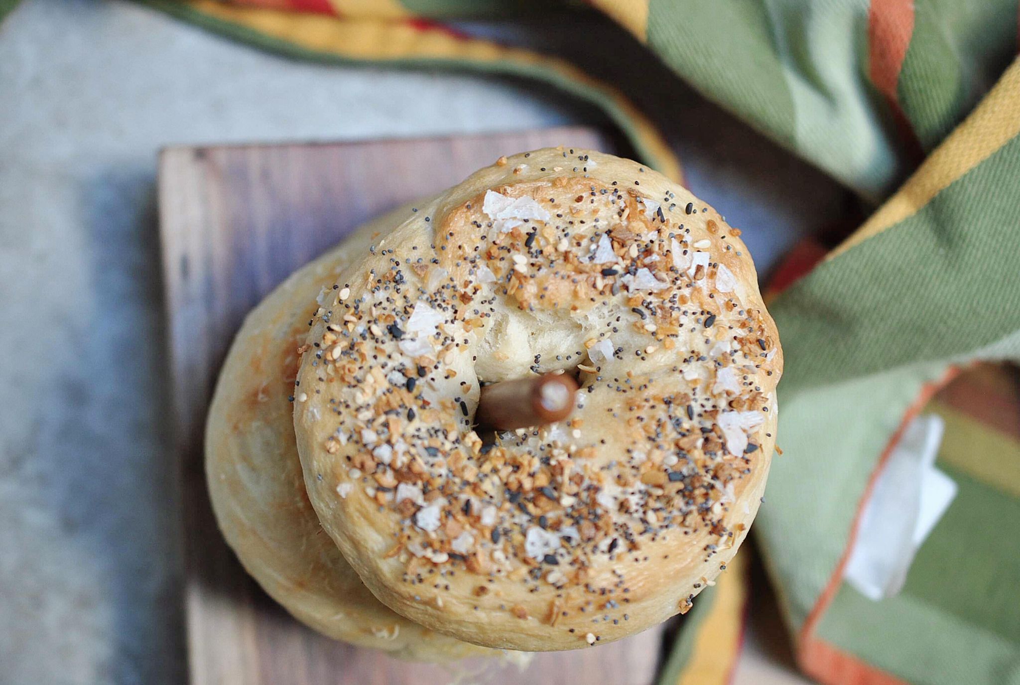 An everything bagel on a cutting board