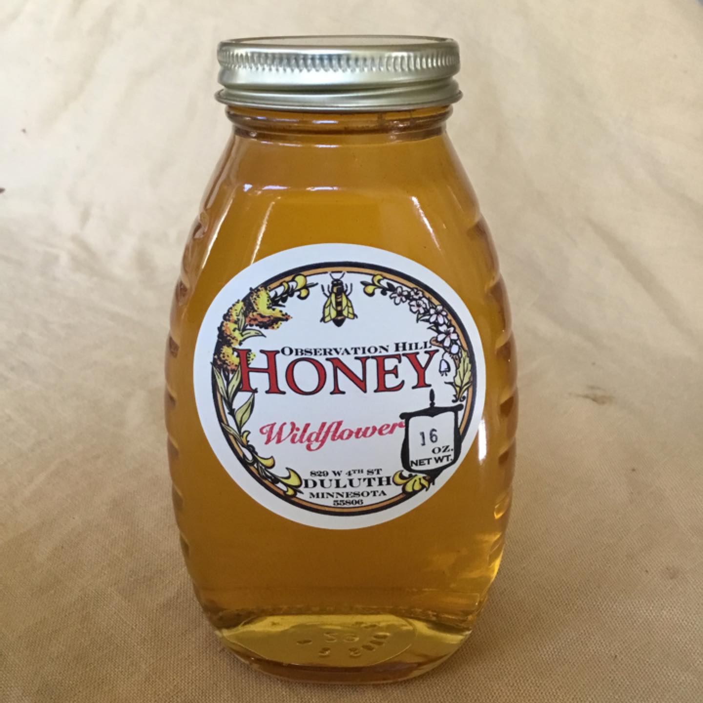 A jar of honey with a label that reads, "Observation Hill Honey, Wildflower, Duluth, Minnesota.