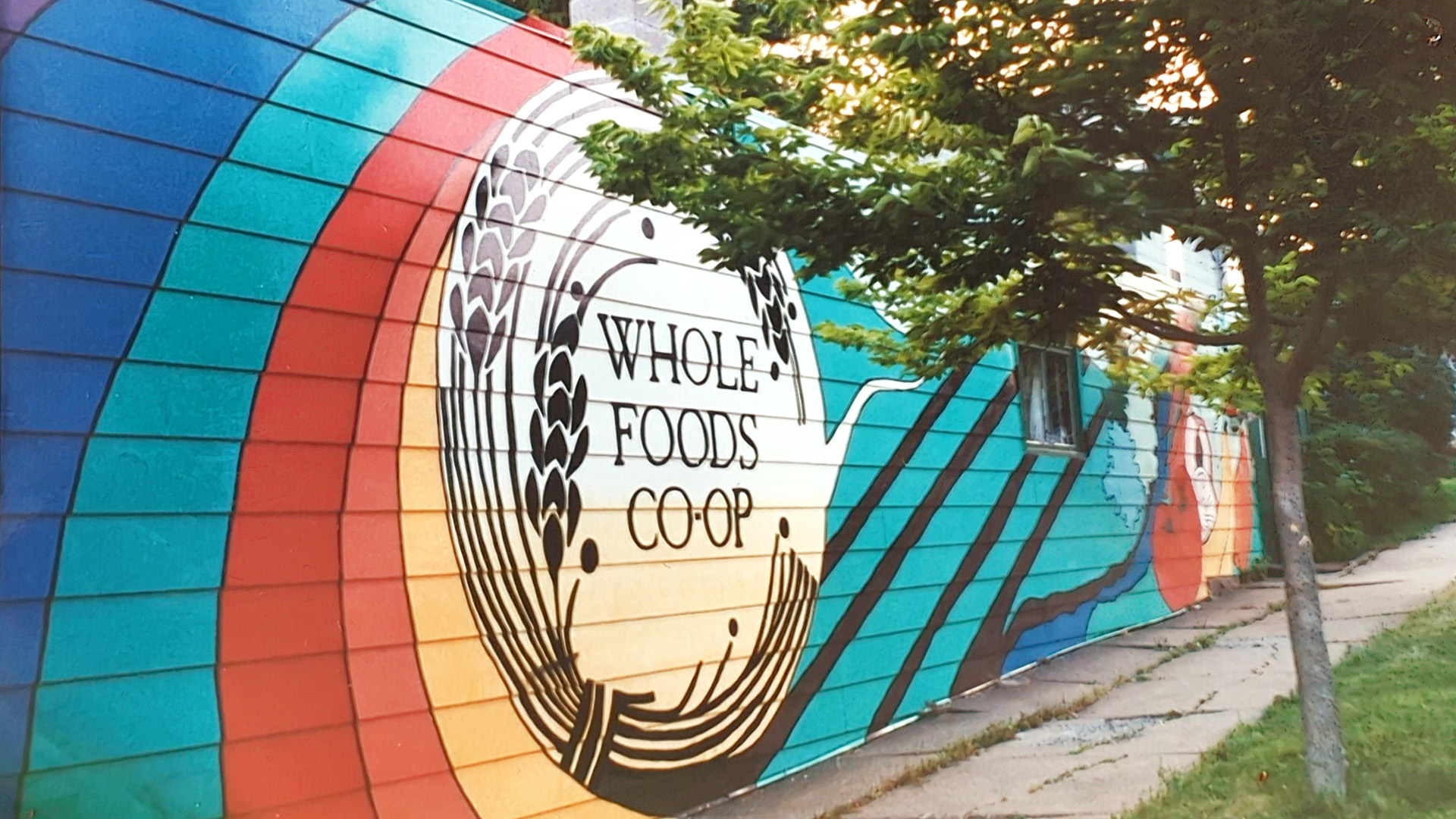 Colorful mural on the side of a building with the words Whole Foods Co-op.
