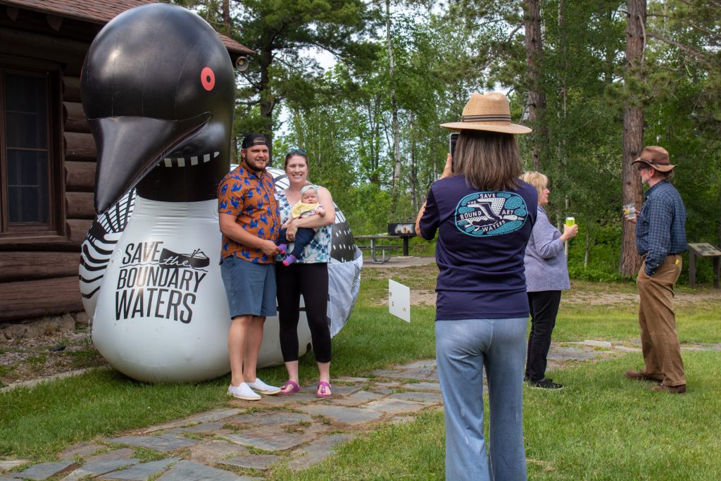 A family poses for a photo in front of a giant inflatable loon with the slogan 