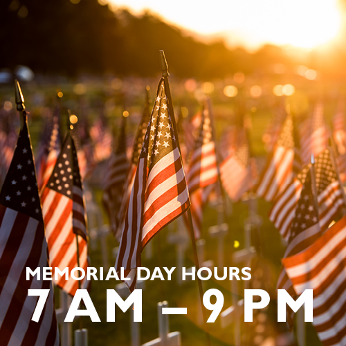 Many flags at sunset with words, "Memorial day Hours 7am-9pm".