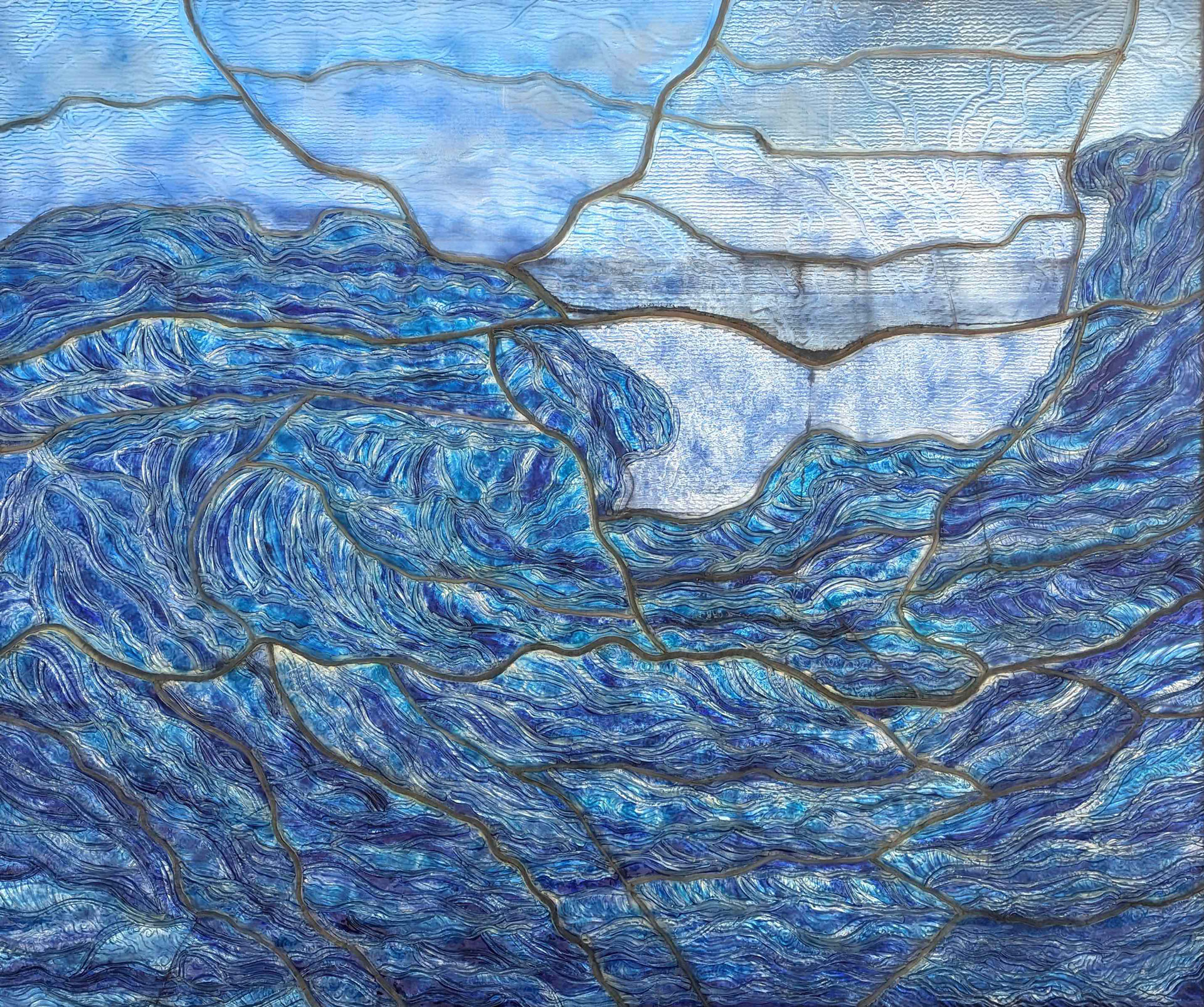 A stained glass window depicting a dynamic ocean scene. The glass pieces are various shades of blue and white, intricately arranged to represent turbulent waves crashing against each other, emulating the movement and depth of the sea.