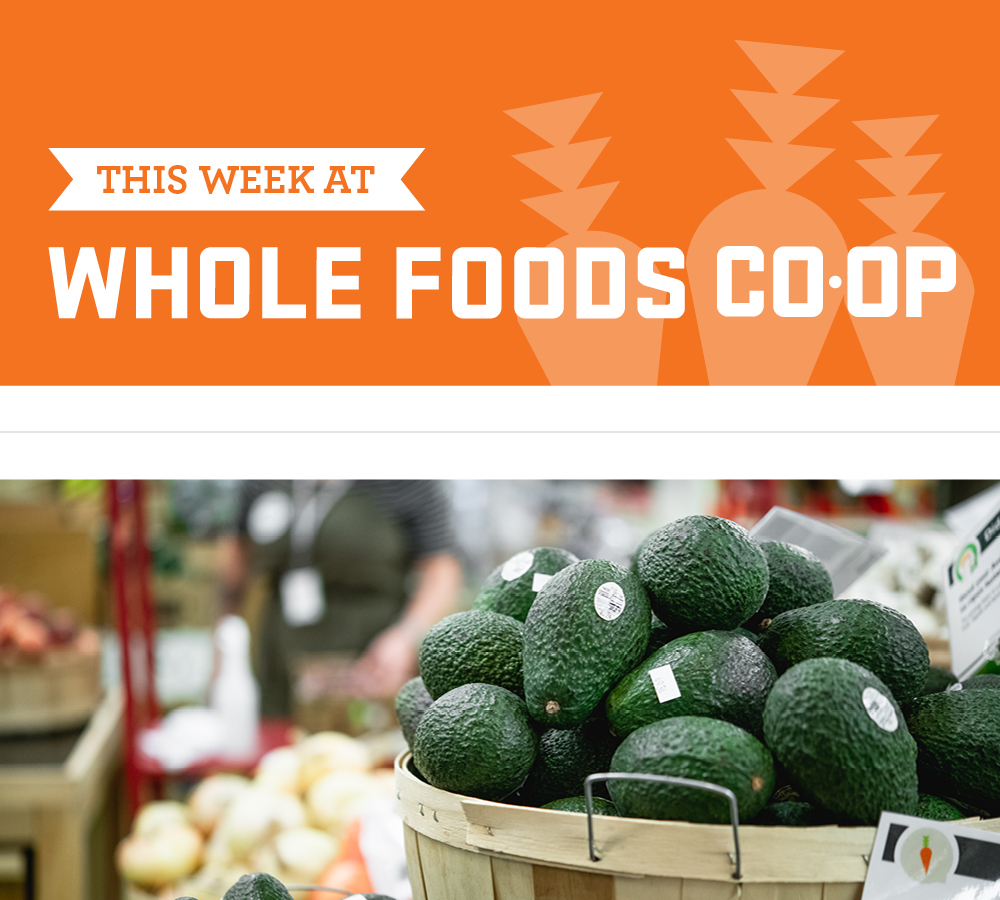 An image of a grocery store advertisement for Whole Foods Coop Duluth. The ad features a bright orange banner at the top with the text "THIS WEEK AT WHOLE FOODS CO-OP" and a basket filled with ripe avocados in the foreground.
