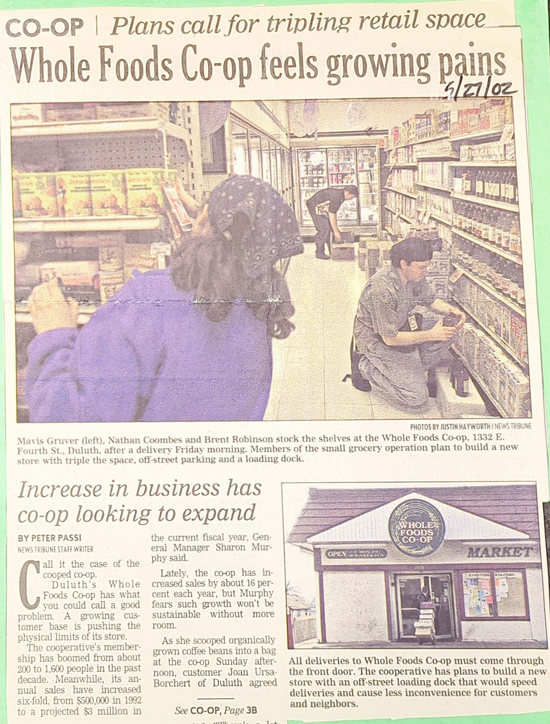 A newspaper article titled "Whole Foods Co-op feels growing pains" discusses the need to triple retail space due to increased business. A photo shows three employees stacking shelves at Whole Foods Coop Duluth MN, while another photo captures the store's exterior.