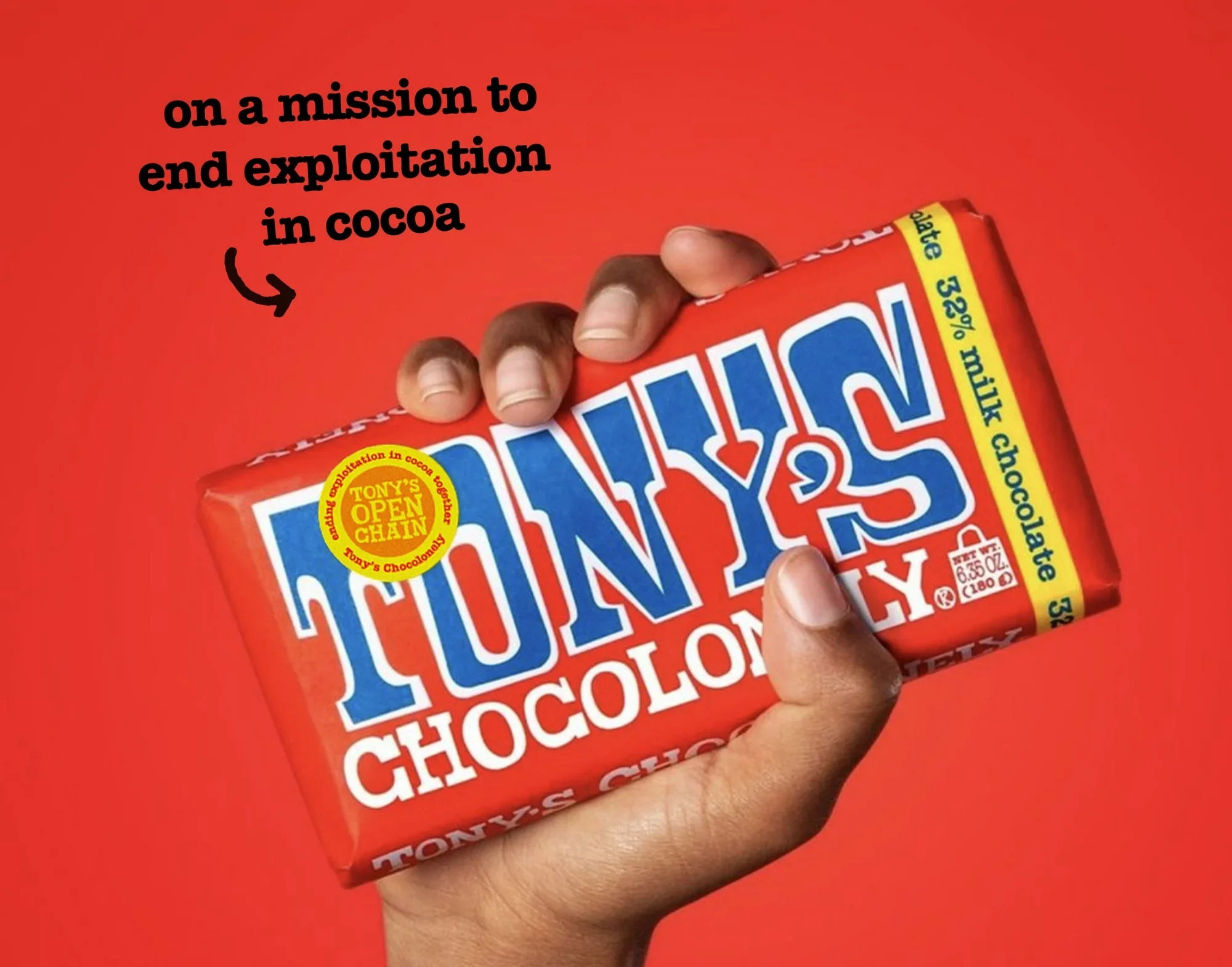 Hand holding a bar of Tony's Chocolonely chocolate with text, "on a mission to end exploitation in cocoa" and an arrow pointing to the chocolate bar, on a red background.