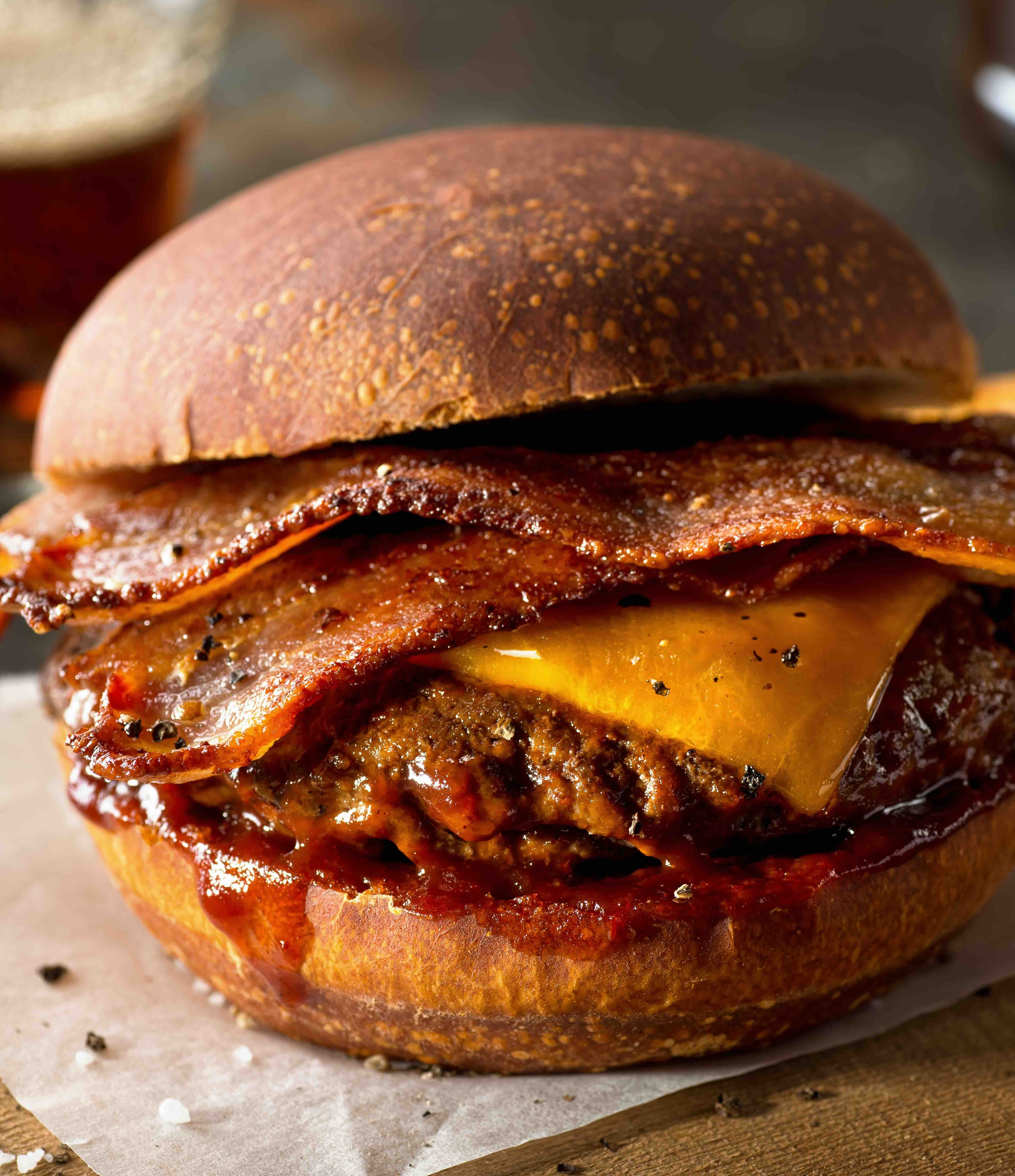 A delicious pub style bacon cheeseburger with barbecue sauce and french fries.