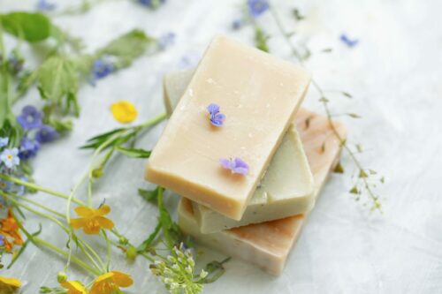 Natural handmade soap bars with organic medicinal plants and flowers.Homemade beauty products with natural essential oils from plants and flowers, top view closeup photo