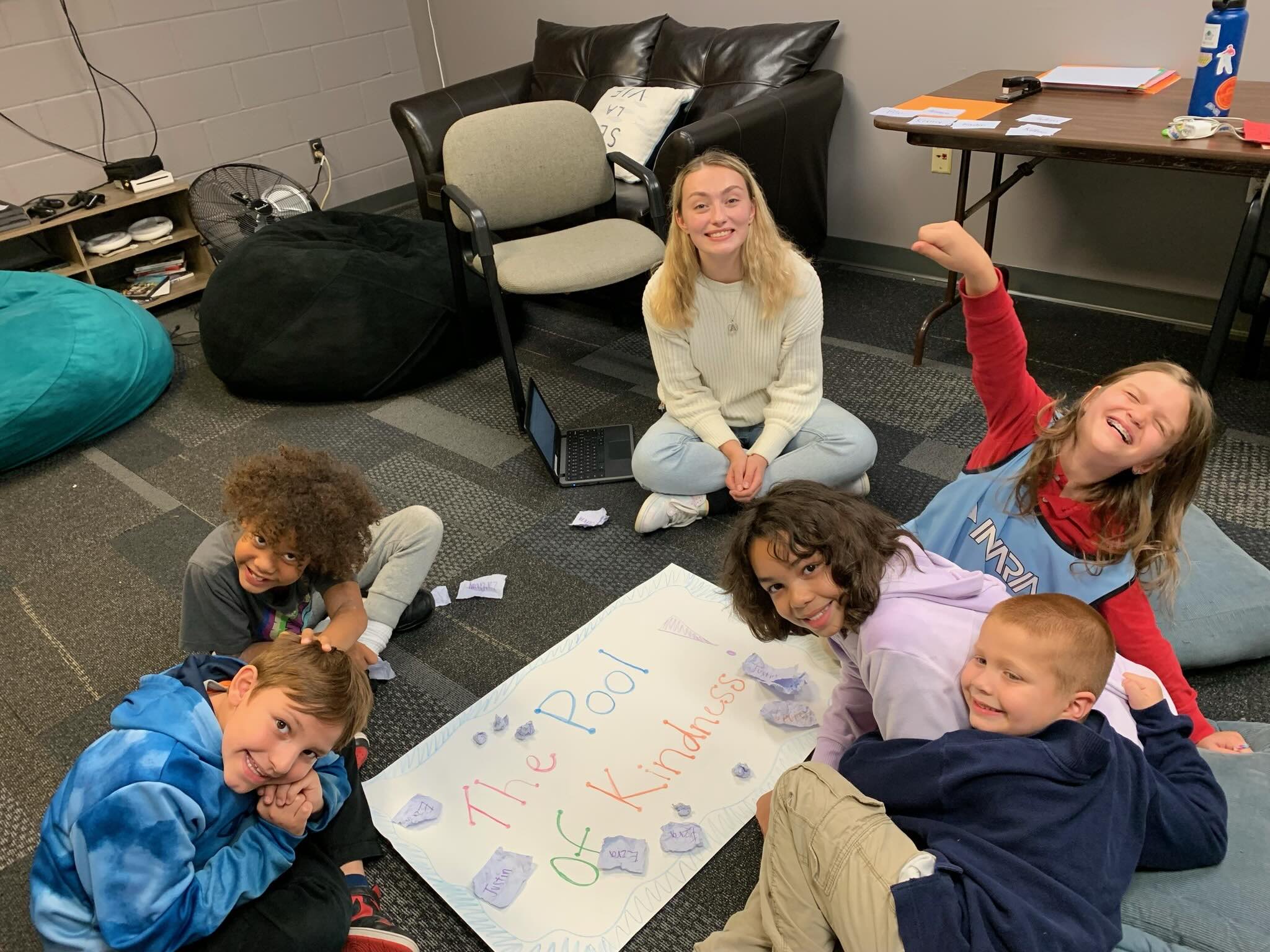 Boys & Girls Clubs of the Northland kids gather around large sheet of paper that says "Pool of Kindness."