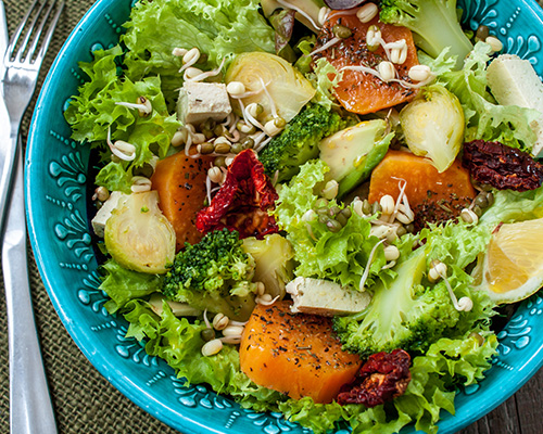 Green salad in a blue bowl.