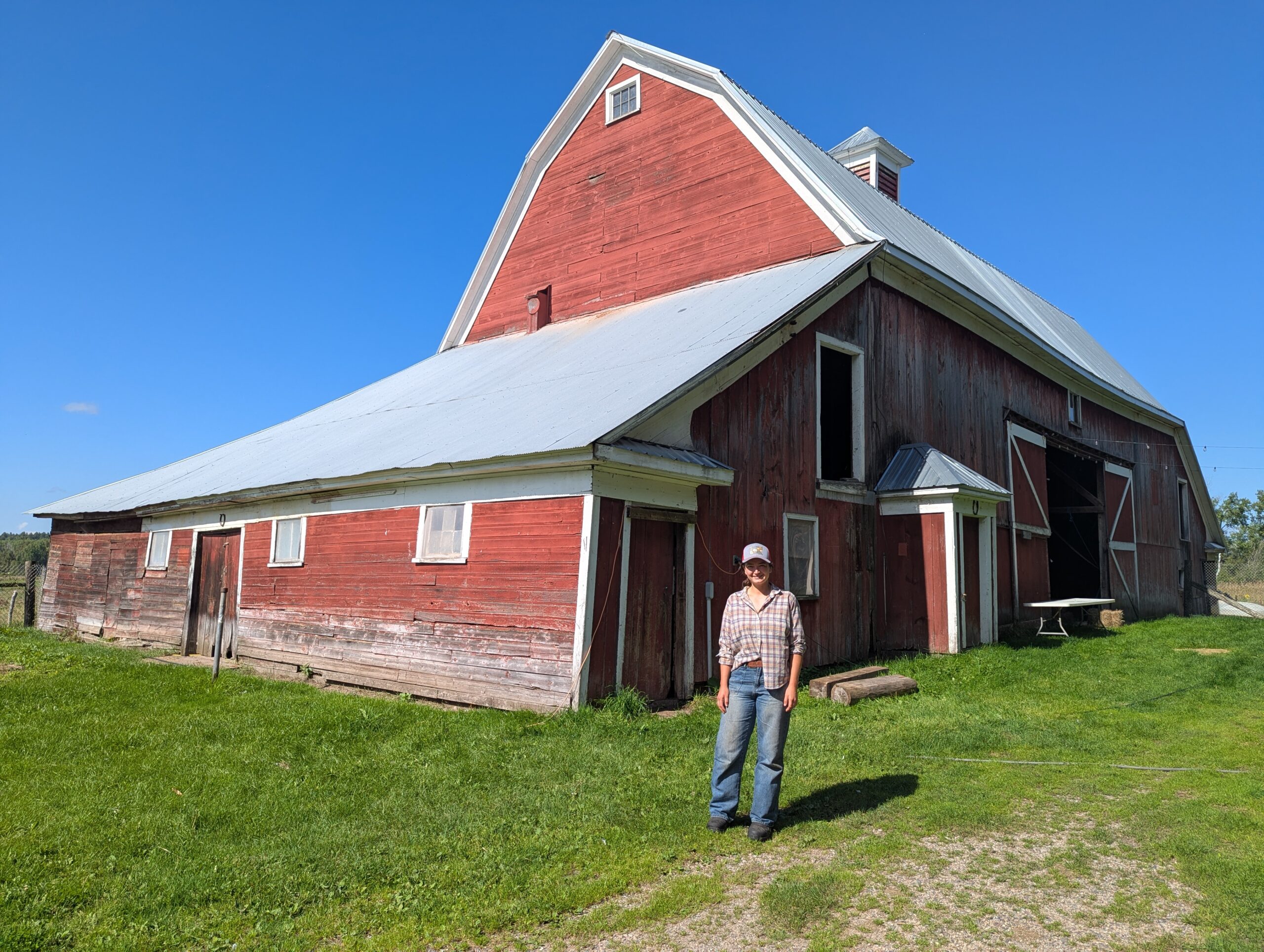 Madeline, owner of Hoop Snake Farm, poses in front of the barn.